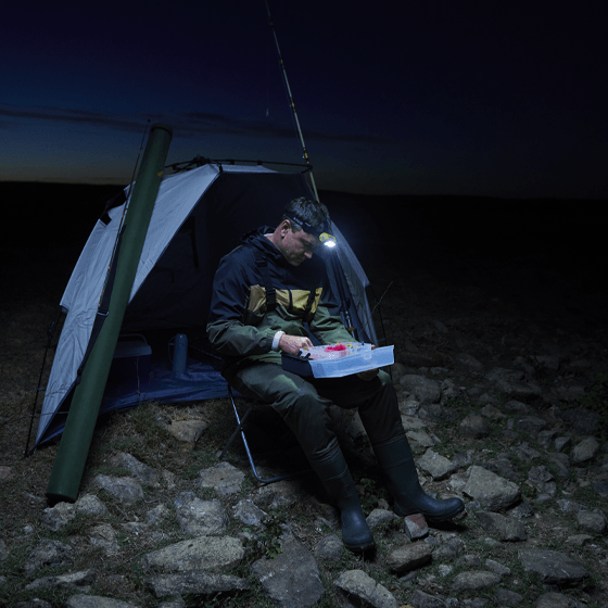 Man using Head Torch while Camping in the dark